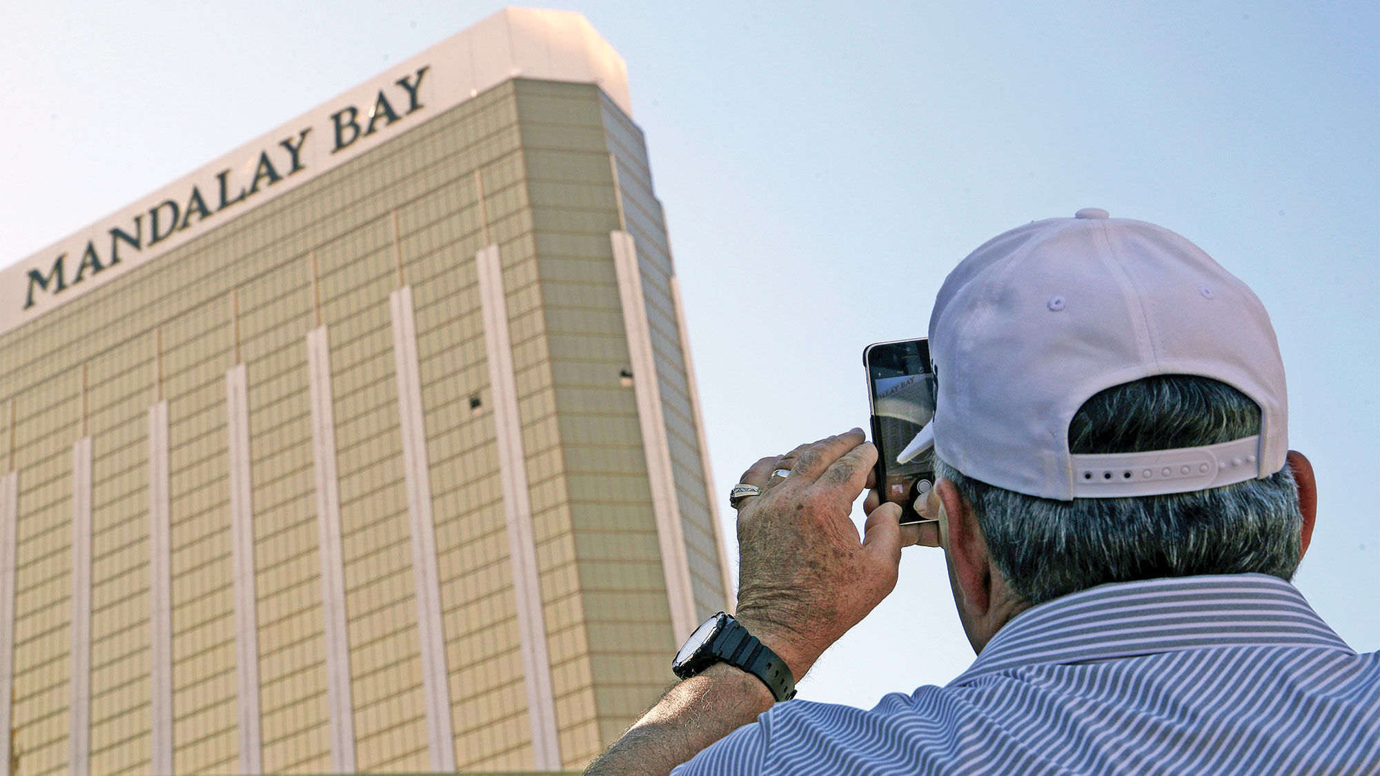 A tourist takes a photo of the broken windows at the Mandalay Bay in Las Vegas on Oct. 4, three days after a gunman opened fire on an outdoor music concert from his perch on the hotel's 32nd floor.