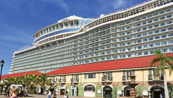The Harmony of the Seas looms over the buildings of the shopping village at the cruise port in Falmouth, Jamaica.