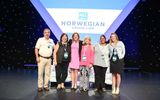 Camille Olivere, senior vice president of sales for Norwegian Cruise Line, poses with winners of sailings on the Norwegian Bliss, drawn during Friday's lunch.