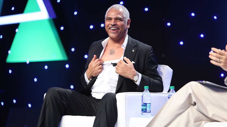 Arnold Donald, CEO of Carnival Corporation & plc, shows off his (mock) chest tattoo of ''Travel Agents Rock'' during his CEO Conversation with Travel Weekly editor in chief Arnie Weissmann. CruiseWord closed Friday, Nov. 17, following three days of agent-focused informational sessions, panel discussions, CEO Conversations and an exhibitor showcase. The event also included a weekend full of ship inspections in Miami and Fort Lauderdale.