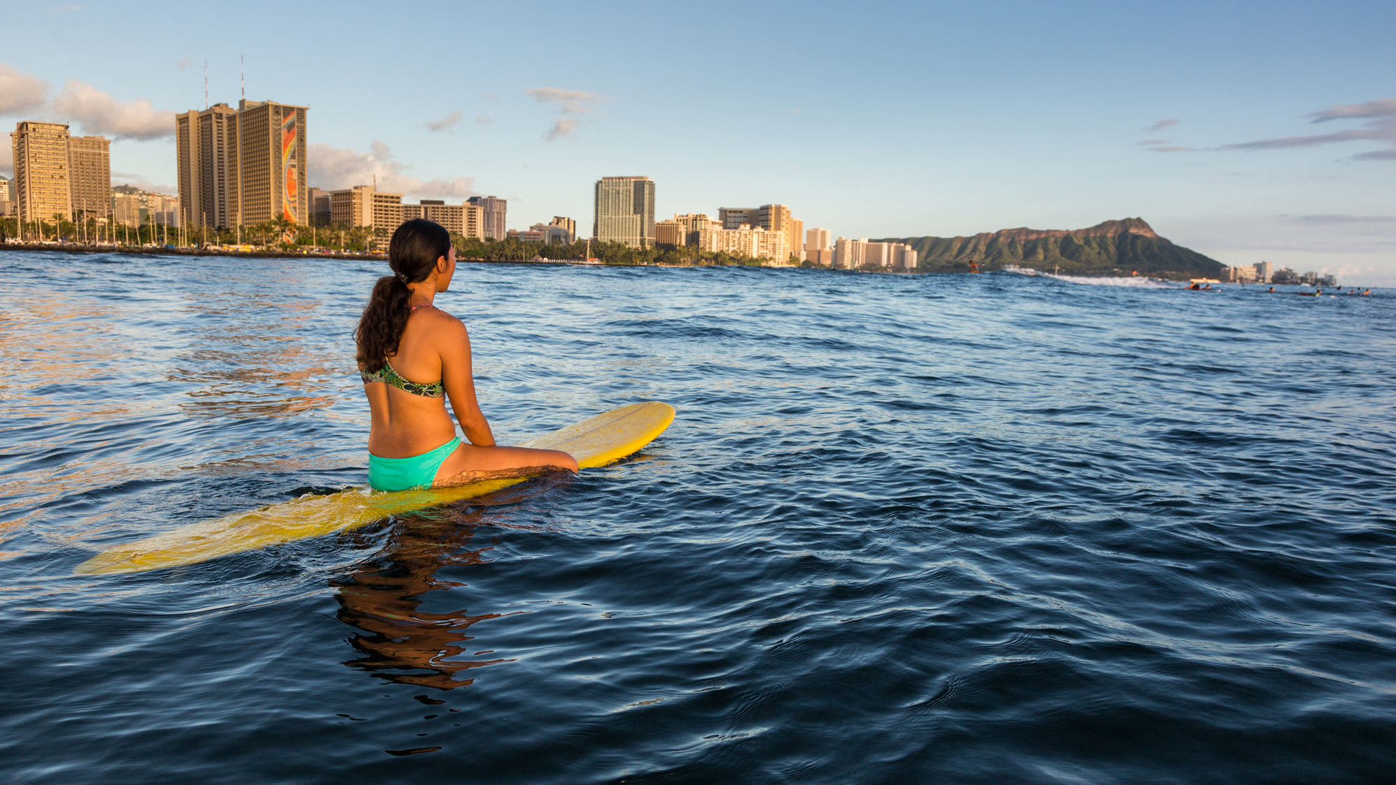 A surfer waits for a wave at a surf break off Waikiki in Honolulu.
