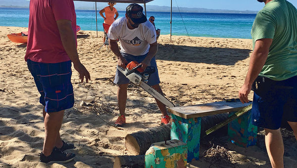 Juan Carlos Rosario, owner of Paradise West Tours, cuts a fallen palm tree during the Crash Boat Beach cleanup. Juan Carlos Rosario, owner of Paradise West Tours, cuts a fallen palm tree during the Crash Boat Beach cleanup.