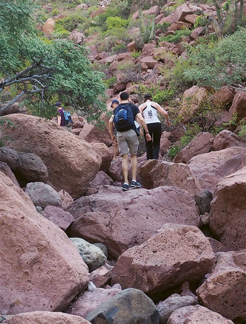 Passengers on a five-mile, 600-foot climb over rocks and boulders to a coastal lookout point atop Isla Partida.
