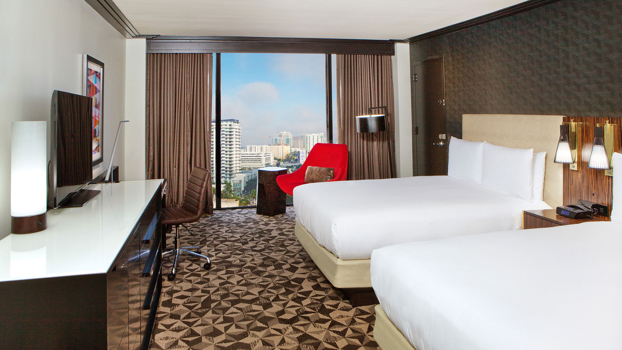 Renovated guestrooms at the Hilton Miami Downtown feature floor-to-ceiling windows with views of the Miami skyline.