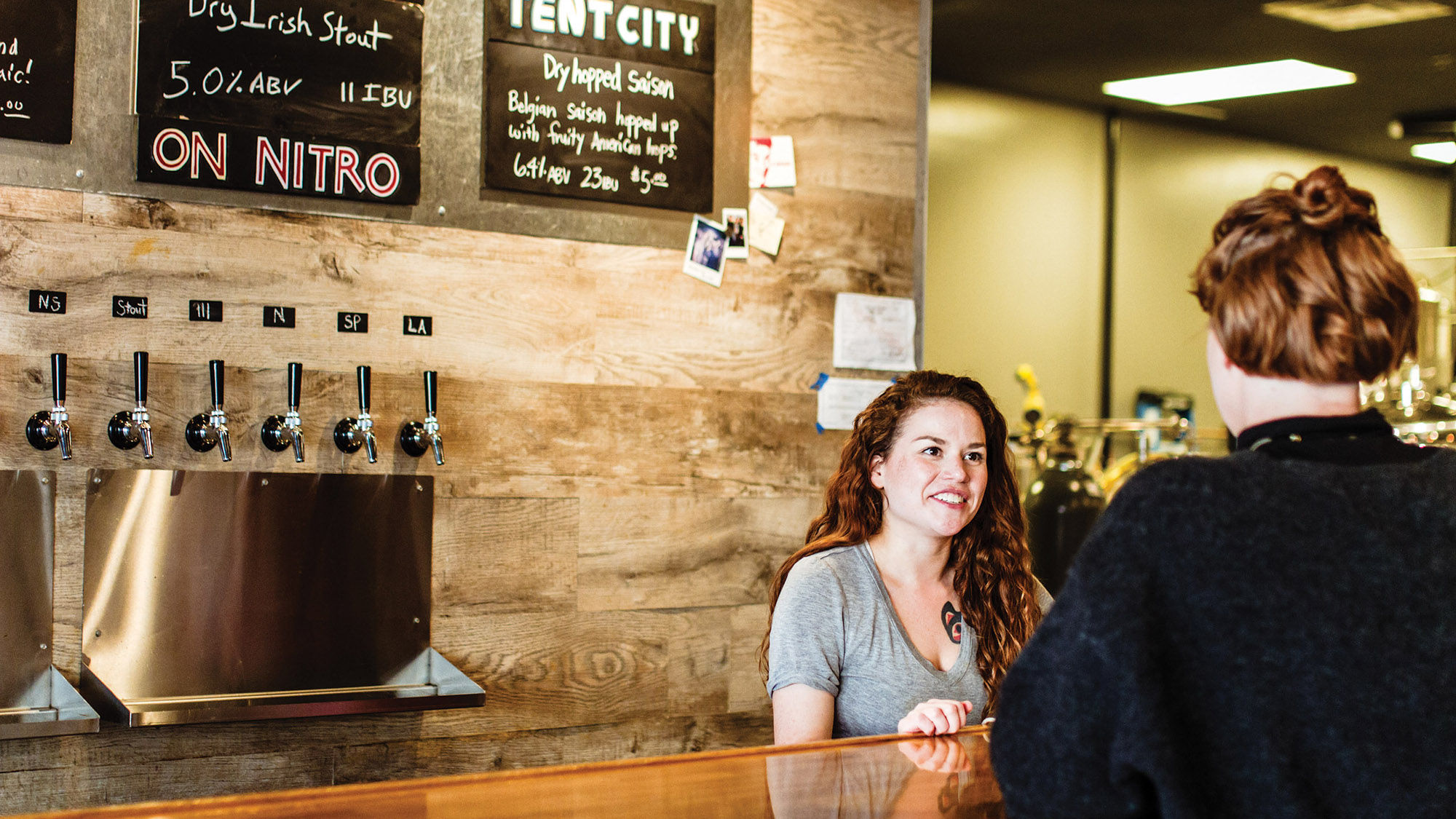 A customer bellies up to the bar at Resolution Brewing in Anchorage. Tour operators have developed products to take advantage of Alaska’s growing craft beer industry.