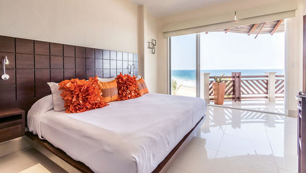 A bedroom with a balcony and sweeping ocean views. A bedroom with a balcony and sweeping ocean views.