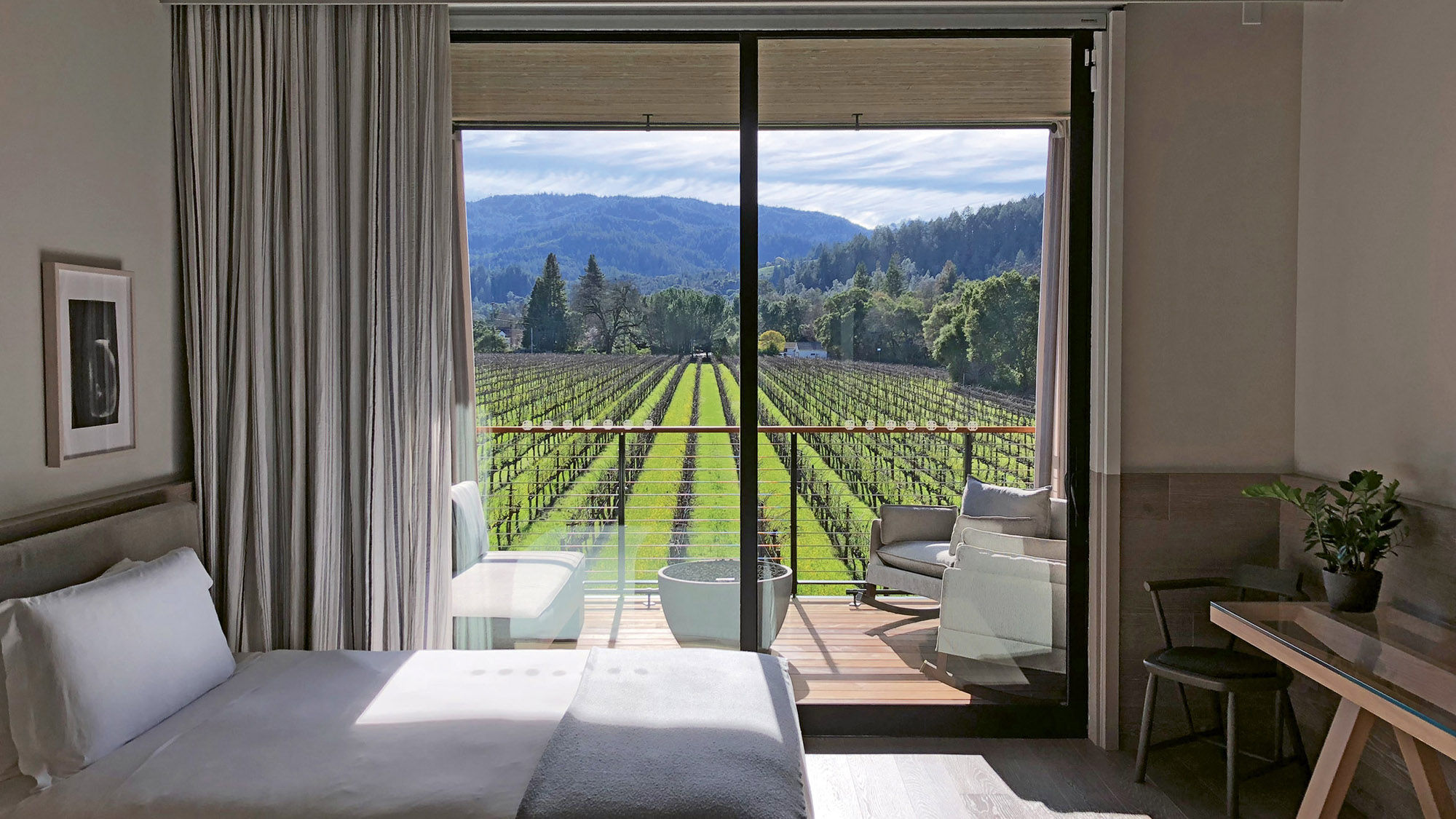 Guestroom balconies with fire pits at Las Alcobas Napa Valley offer postcard views of Beringer Vineyards vines and the mountains.