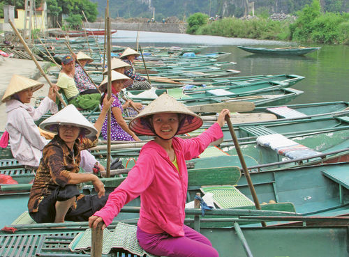 Boats women row with their feet prepare to take guests past limestone formations and through small caves. Boats women row with their feet prepare to take guests past limestone formations and through small caves.