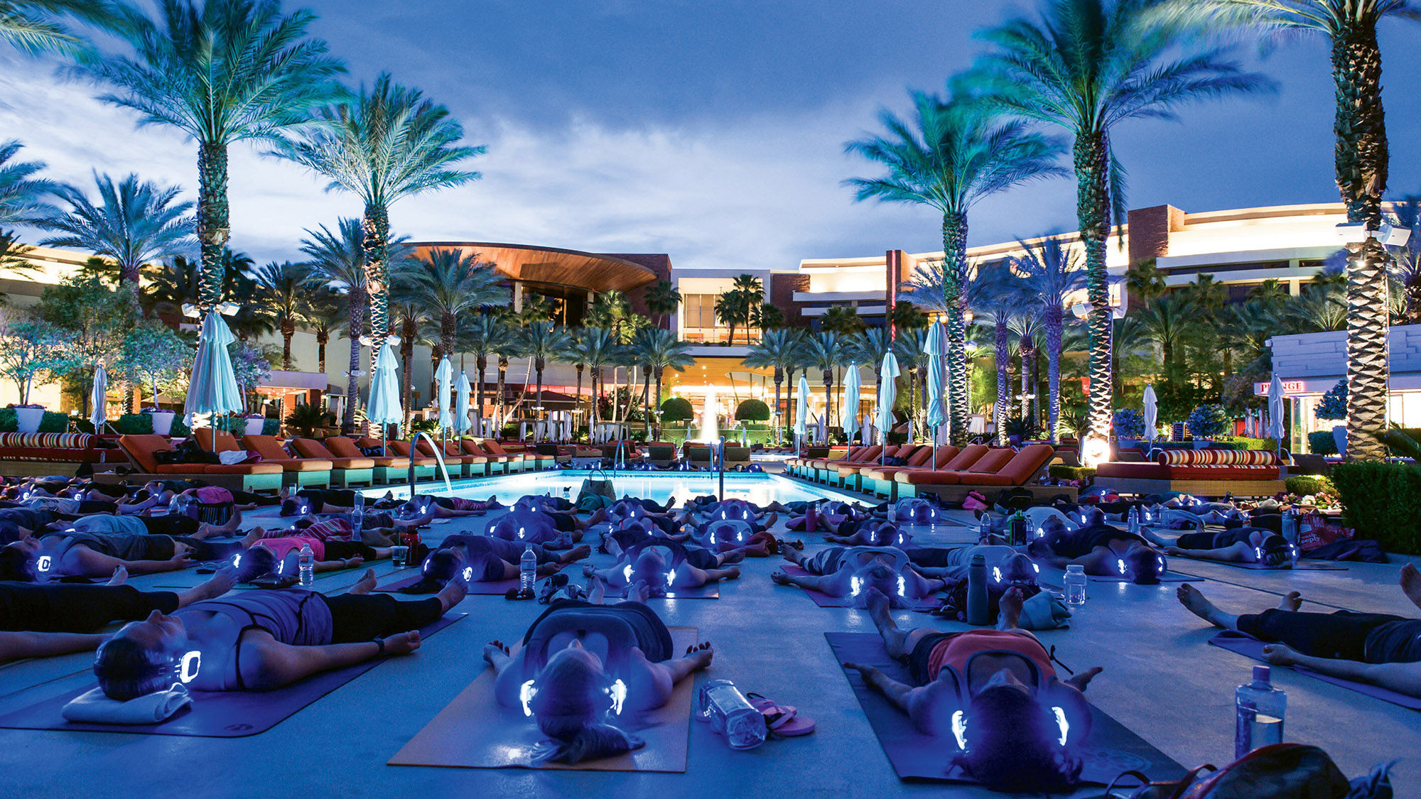 Participants don glowing wireless headphones during a Silent Savasana session at the Red Rock Resort.