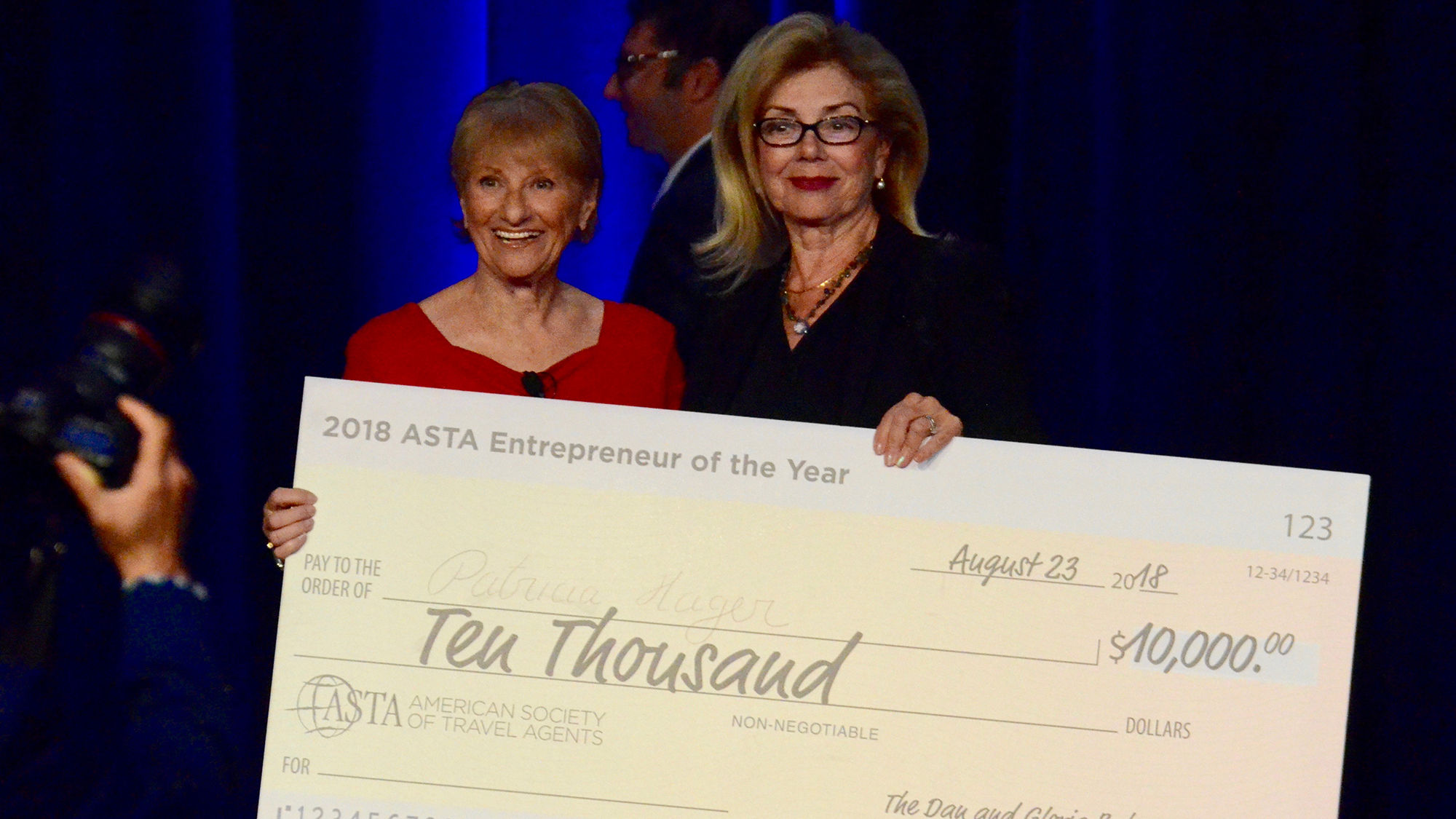 Gloria Bohan, president and CEO of Omega World Travel, presents Patricia Hager, founder of Senior Travel Buddy, with the ASTA Entrepreneur of the Year award.