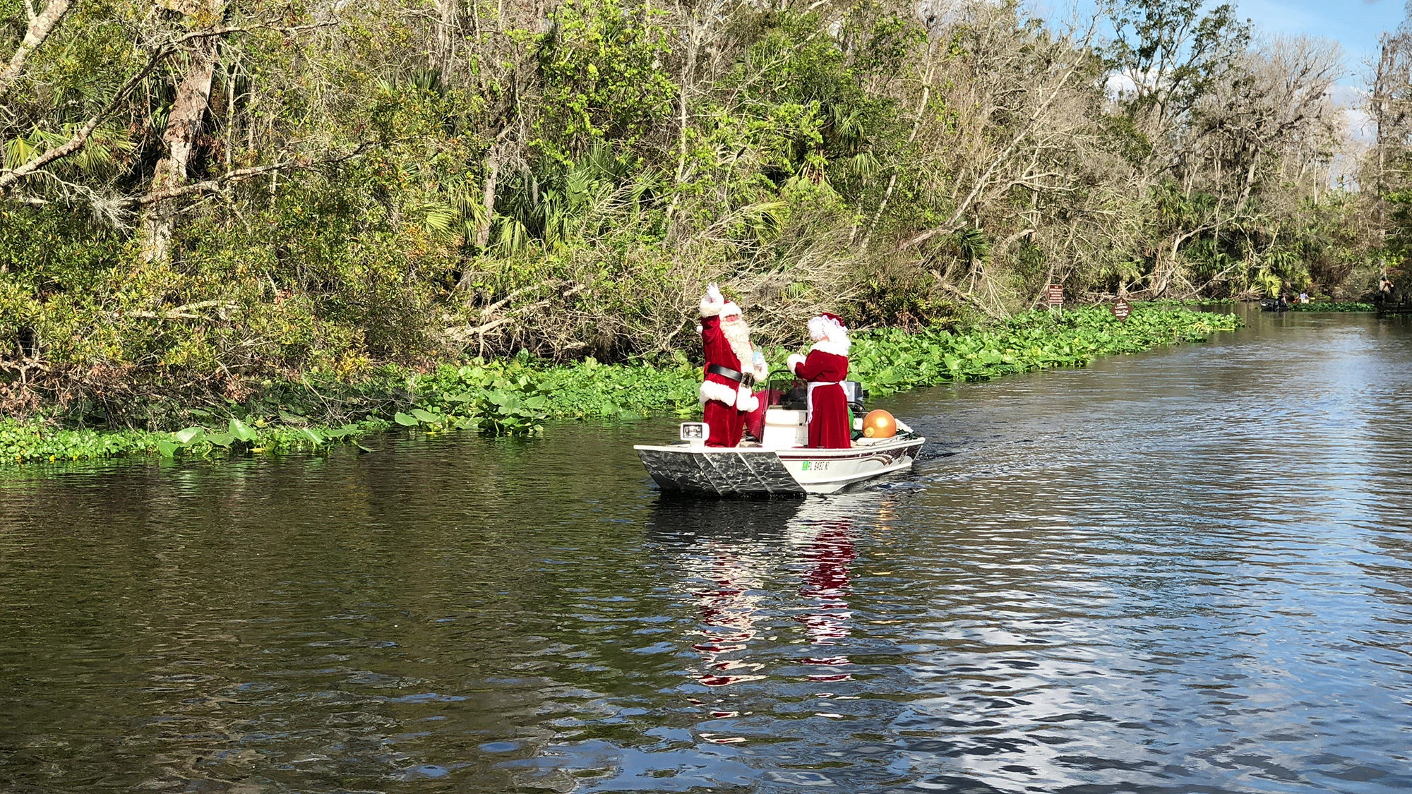 Santa and Mrs. Claus greet fans from their boat on the Wekiva River.