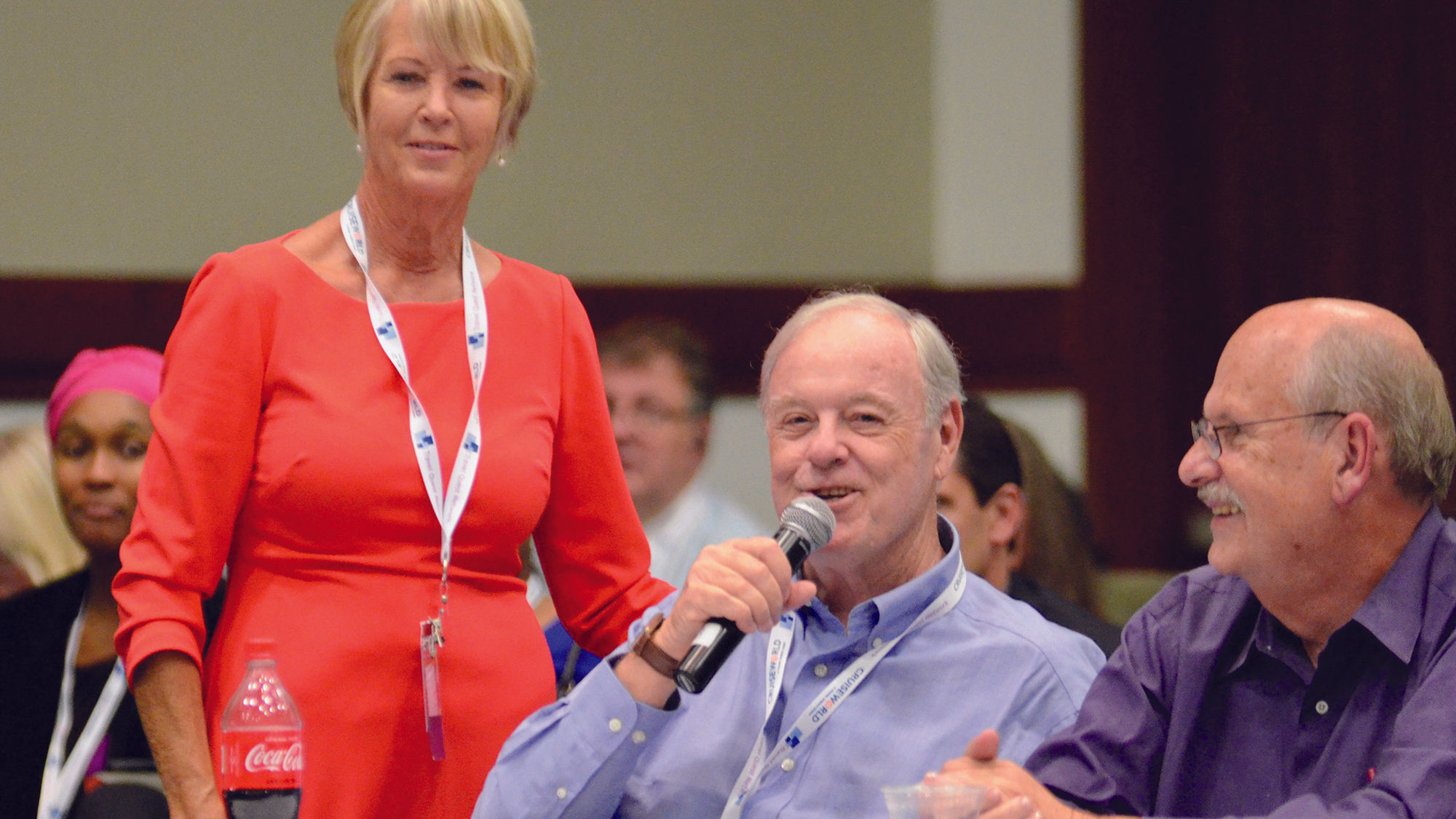 Think Tank moderator Joanie Ogg hands the mike to Geoff Millar of Ultimate All-Inclusive Travel. Cruise specialist Craig Satterfield looks on.