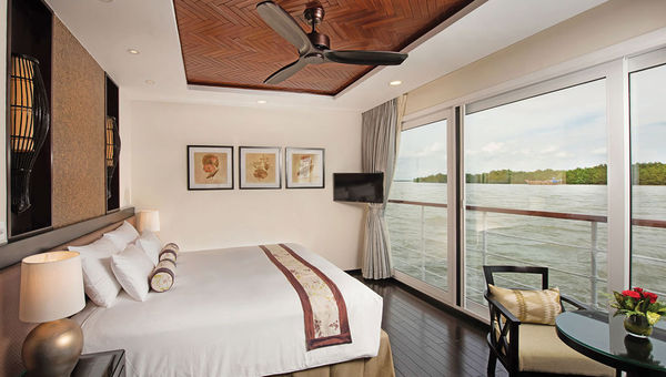 A suite onboard the ship with floor-to-ceiling, sliding glass doors.