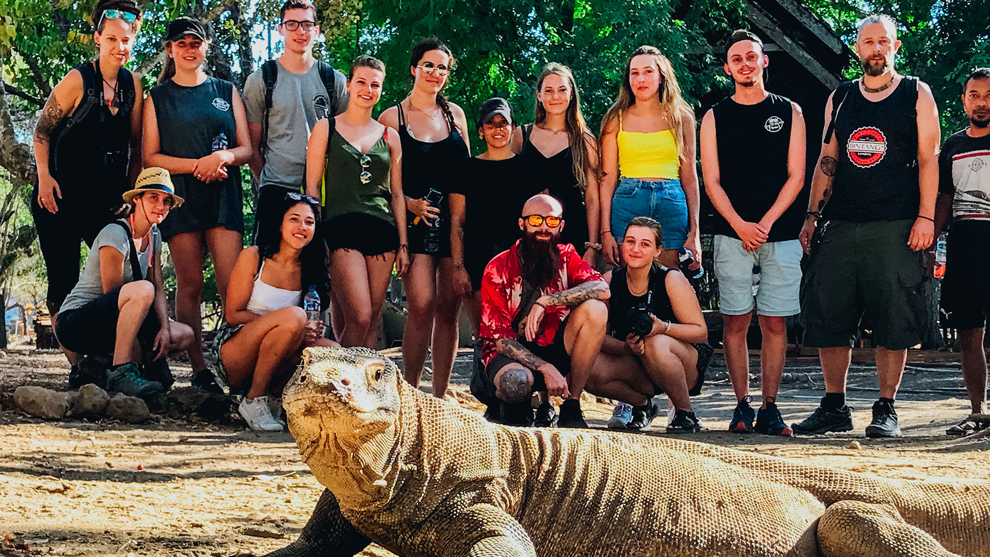 A TruTravels tour group with a Komodo dragon in Indonesia.