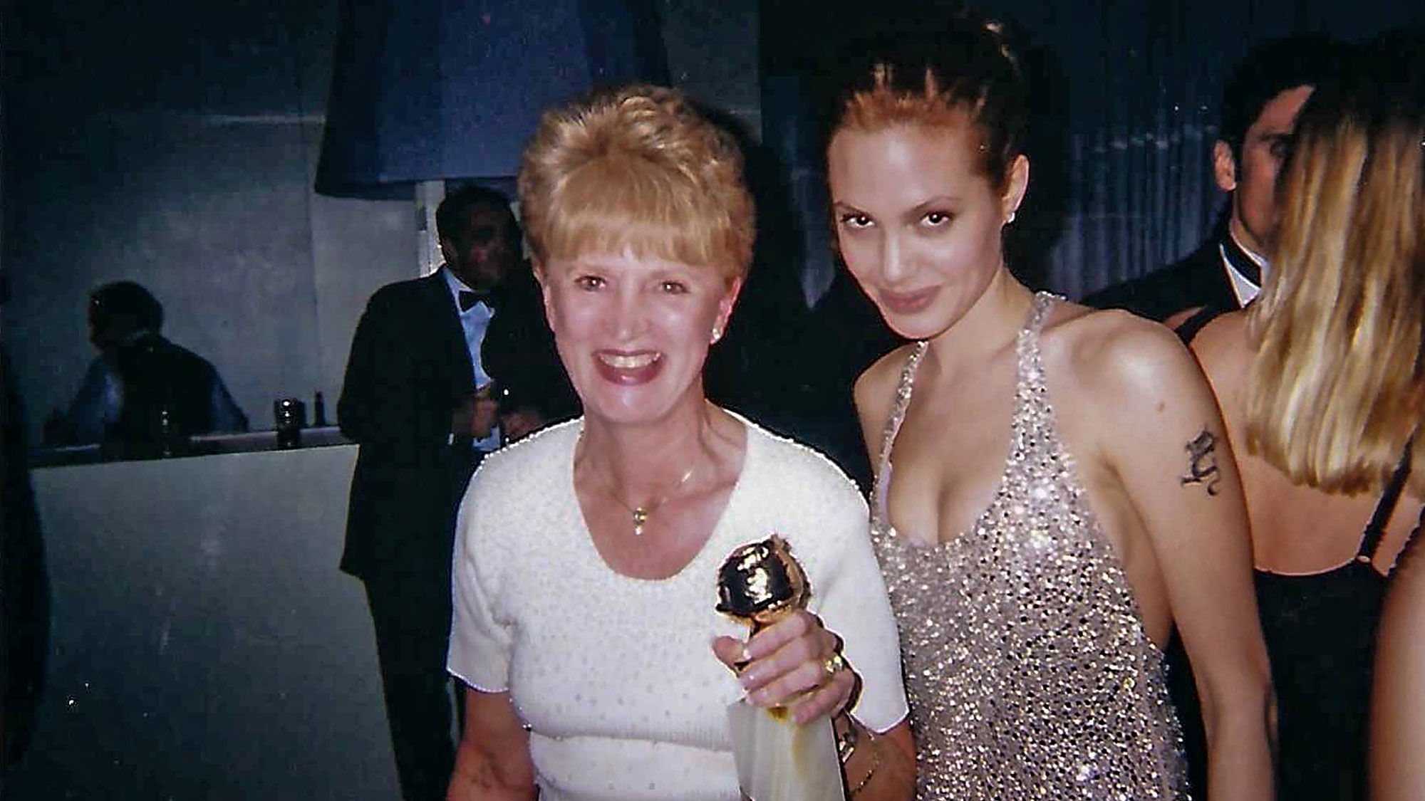 Ruth Turpin holding Angelina Jolie's Golden Globe shortly before the actress jumped into the pool to celebrate her 1999 win for the movie "Gia."