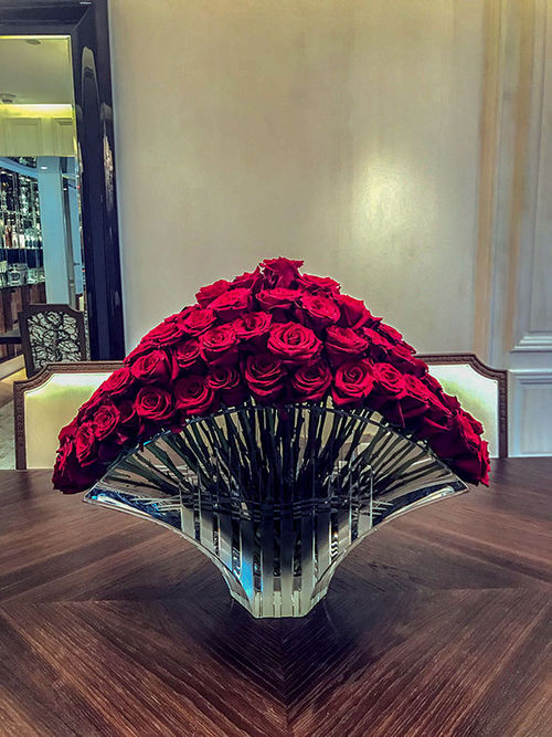 A vase of perfect Baccarat-red roses on the dining table of the Baccarat Suite in the Baccarat Hotel New York.