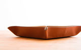 Rarely would a traveler take along a desk piece on a trip, but this elegant item is perfect for keeping a wallet, loose change, keys, jewelry and the like on, say, a hotel desk, dresser or night table. Made of high-quality French calfskin and suede-like leather called nubuck, and finished with hand-burnished edges, the catch-all folds flat for packing and opens into a beautiful valet tray with side enclosures. Crafted in the U.S. and designed by the New York-based Anson Calder company, the catch-all measures 9 by 9 by 1 inches assembled, and its base is 7 by 7 inches.