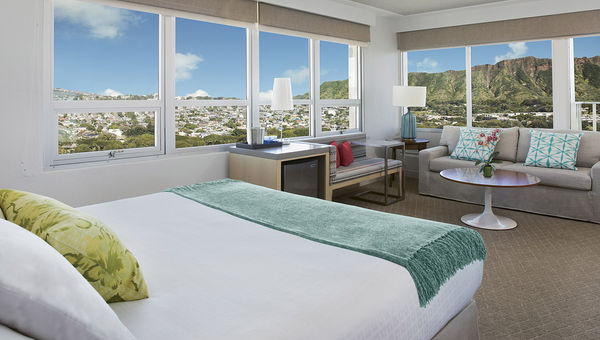 Guestrooms at the Queen Kapiolani feature large windows, letting in expansive Waikiki views.