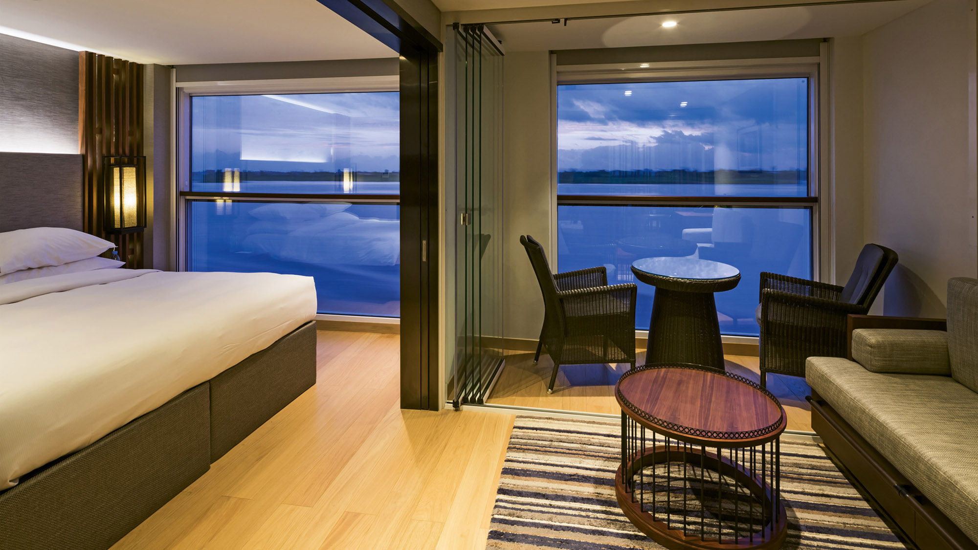 This spacious deluxe suite onboard the Scenic Spirit features floor-to-ceiling windows.