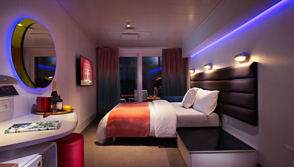 A Virgin Voyages cabin at nighttime, with the Seabed converted from a lounger to a full bed.
