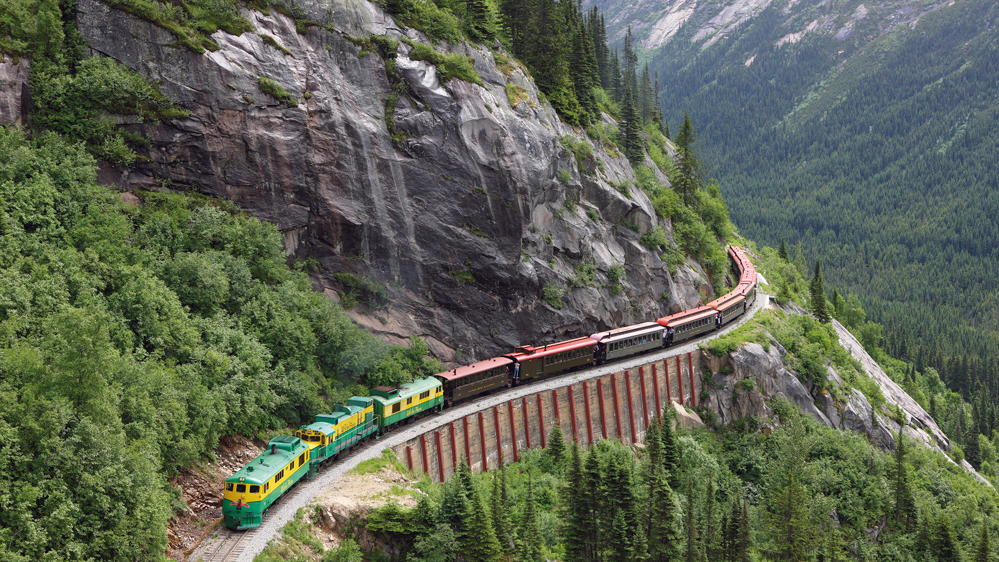 A White Pass & Yukon Route Railway diesel-electric locomotive hugs the mountainside.
