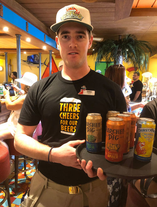 A waiter on the Carnival Magic with cans of the three beers brewed for Carnival Cruise Line. A waiter on the Carnival Magic with cans of the three beers brewed for Carnival Cruise Line.