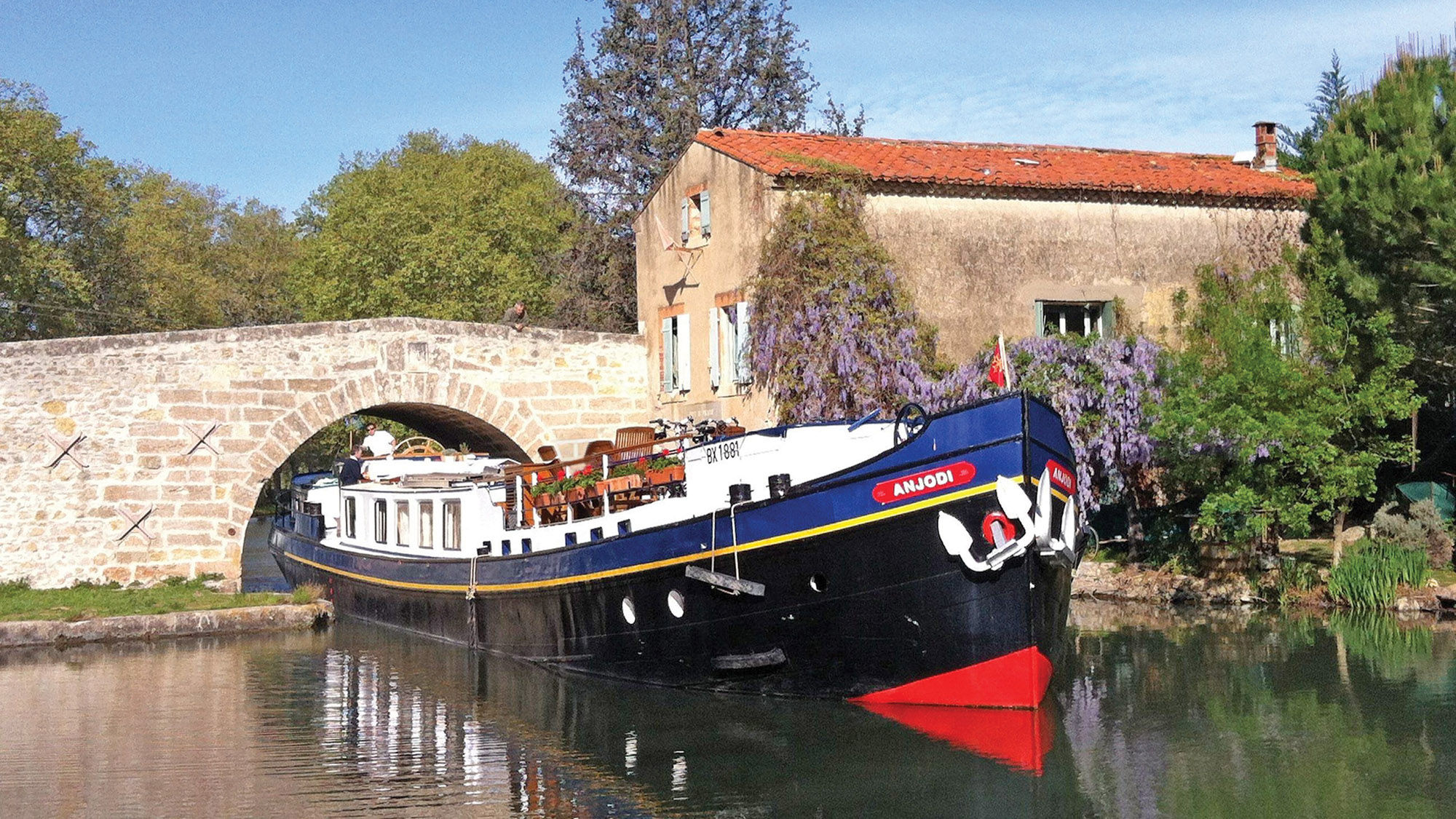 European Waterways’ Anjodi cruising under a bridge. The line’s 17 barges ply waterways that river cruise ships cannot.