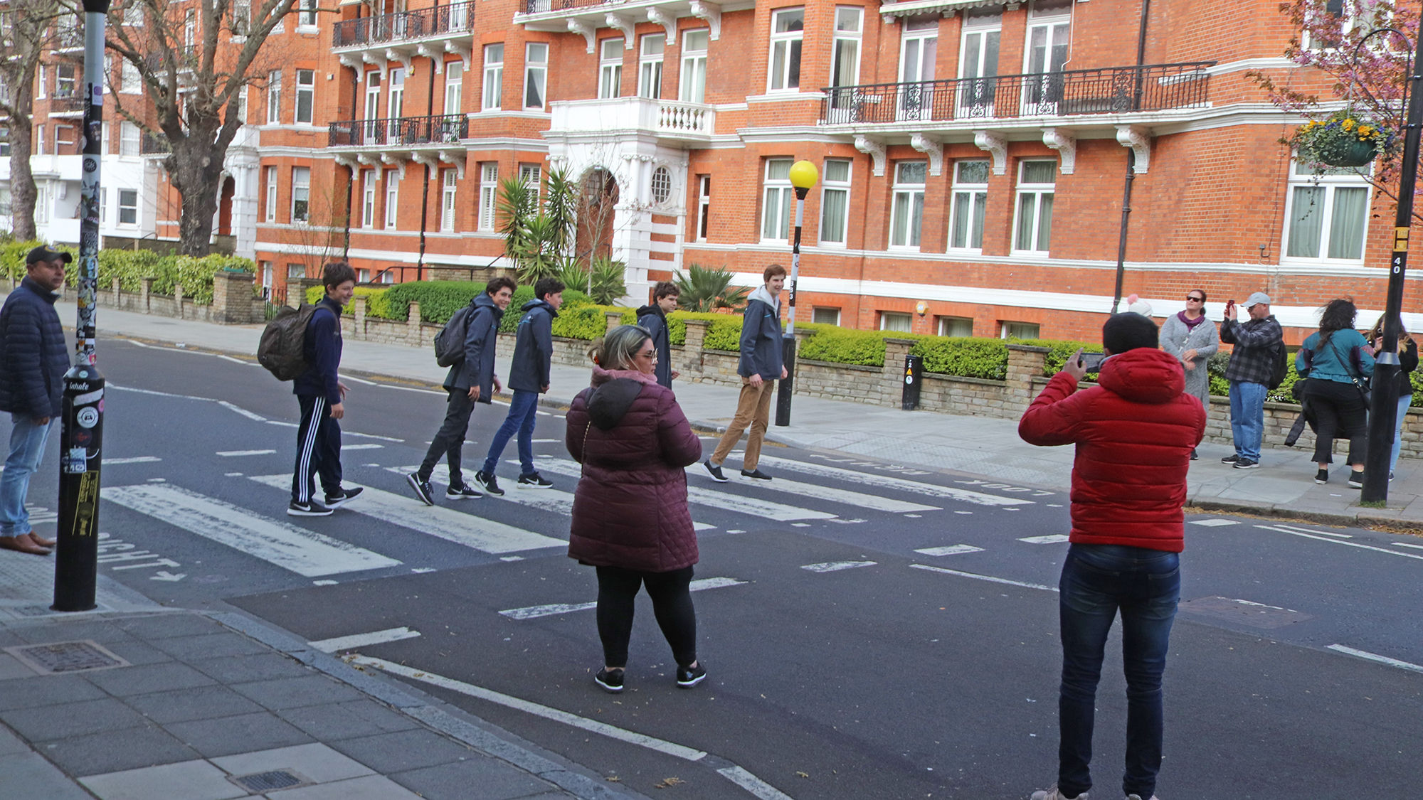 Tourists at the Abbey Road crosswalk, made famous by the Beatles' Abbey Road album cover.