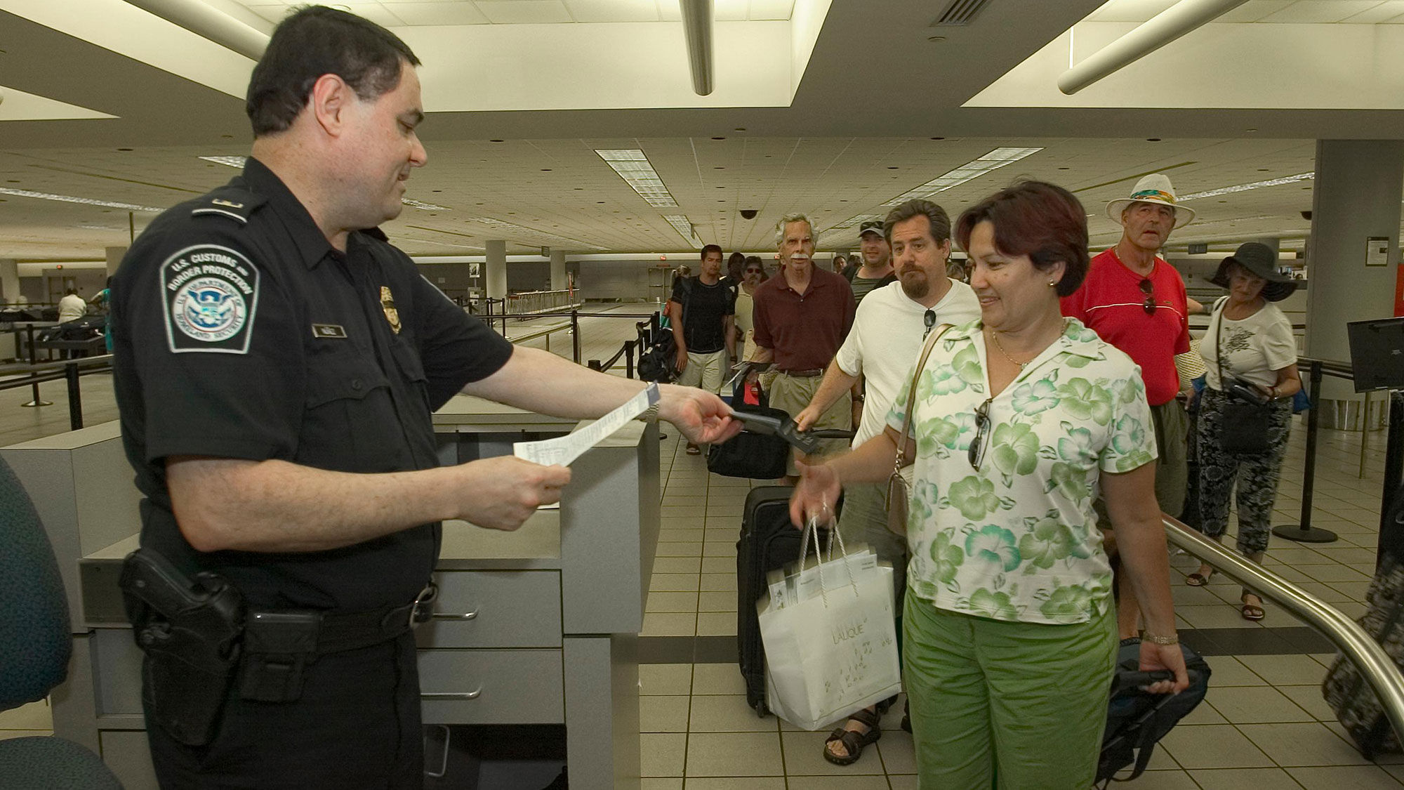 A CBP officer checks a passenger's documentation.