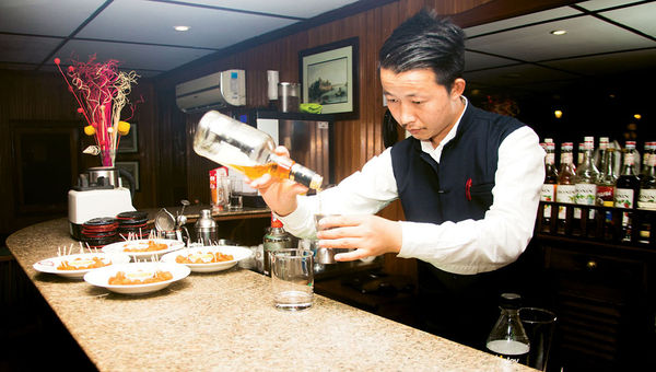 A bartender makes a drink in the ship’s saloon, which was open for an hour or two in the evenings. A bartender makes a drink in the ship’s saloon, which was open for an hour or two in the evenings.