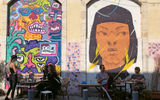 Tel Avivians drink coffee on a street in Old Jaffa. Tel Aviv and Jaffa are full of colorful street murals.