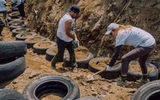 To build a retaining wall, volunteers packed old tires with dirt...
