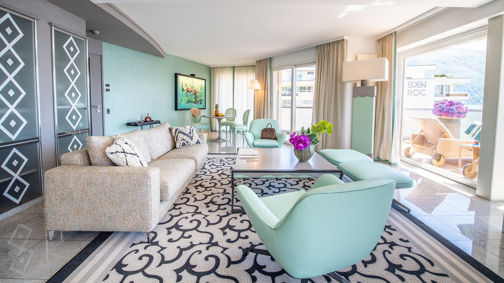 The living area of a Grand Suite at the Hotel Eden Roc features picture windows and terraces overlooking Switzerland’s Lake Maggiore.