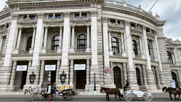 Horse carriages pass the National Theater in Vienna’s city center. Horse carriages pass the National Theater in Vienna’s city center.