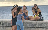 Teenage girls hang out on Havana's seven-mile-long seawall.