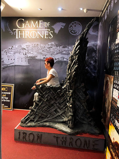 A tourist takes a photo while sitting on an Iron Throne replica at a souvenir shop in Dubrovnik's Old Town. A tourist takes a photo while sitting on an Iron Throne replica at a souvenir shop in Dubrovnik's Old Town.