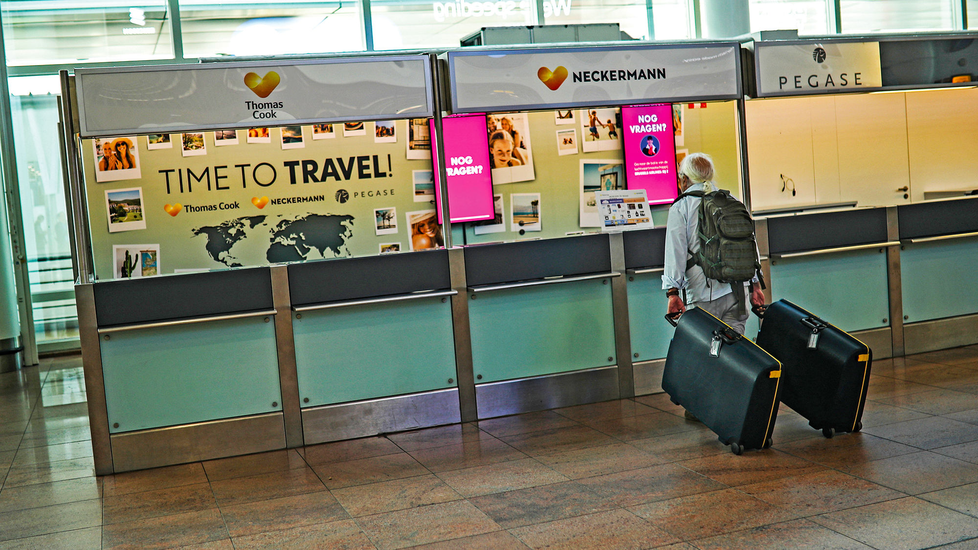 A traveler at Brussels Airport stands by an empty service counter of Neckermann, part of Thomas Cook.