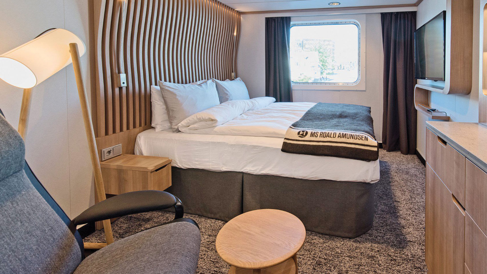 A standard cabin on Hurtigruten's Roald Amundsen features two contemporary chairs rather than the usual small sofa.
