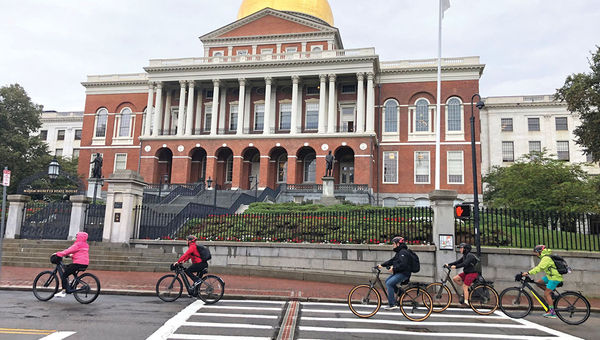 Bike tour participants pedal past the Massachusetts Statehouse in Boston. Bike tour participants pedal past the Massachusetts Statehouse in Boston.