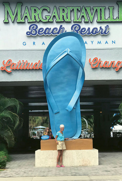 The author poses before the giant, peacock blue sandal sculpture at the entrance to the resort.