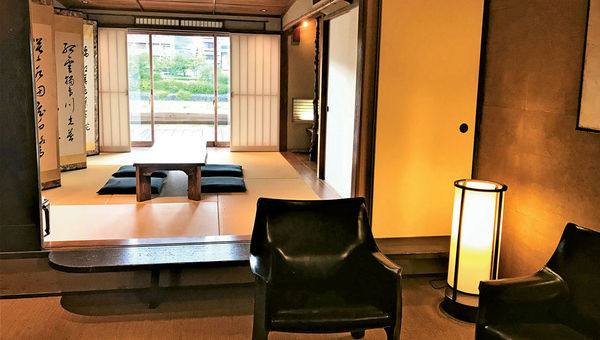 The lower level of the Kyoto machiya has a living and dining room with a blend of modern and traditional furnishings. The lower level of the Kyoto machiya has a living and dining room with a blend of modern and traditional furnishings.