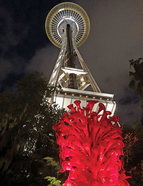 A nighttime view of the Space Needle, with a glass sculpture from the Chihuly Garden in the foreground. A nighttime view of the Space Needle, with a glass sculpture from the Chihuly Garden in the foreground.