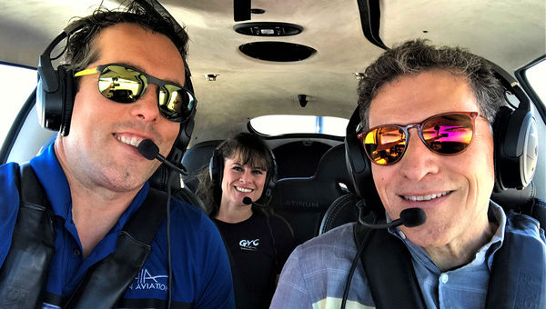 Paul Sallach, co-president of All in Aviation, left, and Travel Weekly editor in chief Arnie Weissmann, in a mid-flight selfie. Sitting behind is Gina Yager, owner, GYC Vegas, All in Aviation’s public relations firm. Paul Sallach, co-president of All in Aviation, left, and Travel Weekly editor in chief Arnie Weissmann, in a mid-flight selfie. Sitting behind is Gina Yager, owner, GYC Vegas, All in Aviation’s public relations firm.