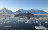 The Le Lyrial and its reflection in the water on a still evening in Antarctica.