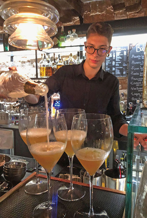 A bartender at the Oficina Ormesini restaurant pours a Bellini cocktail of peach juice and prosecco, a Venetian classic.