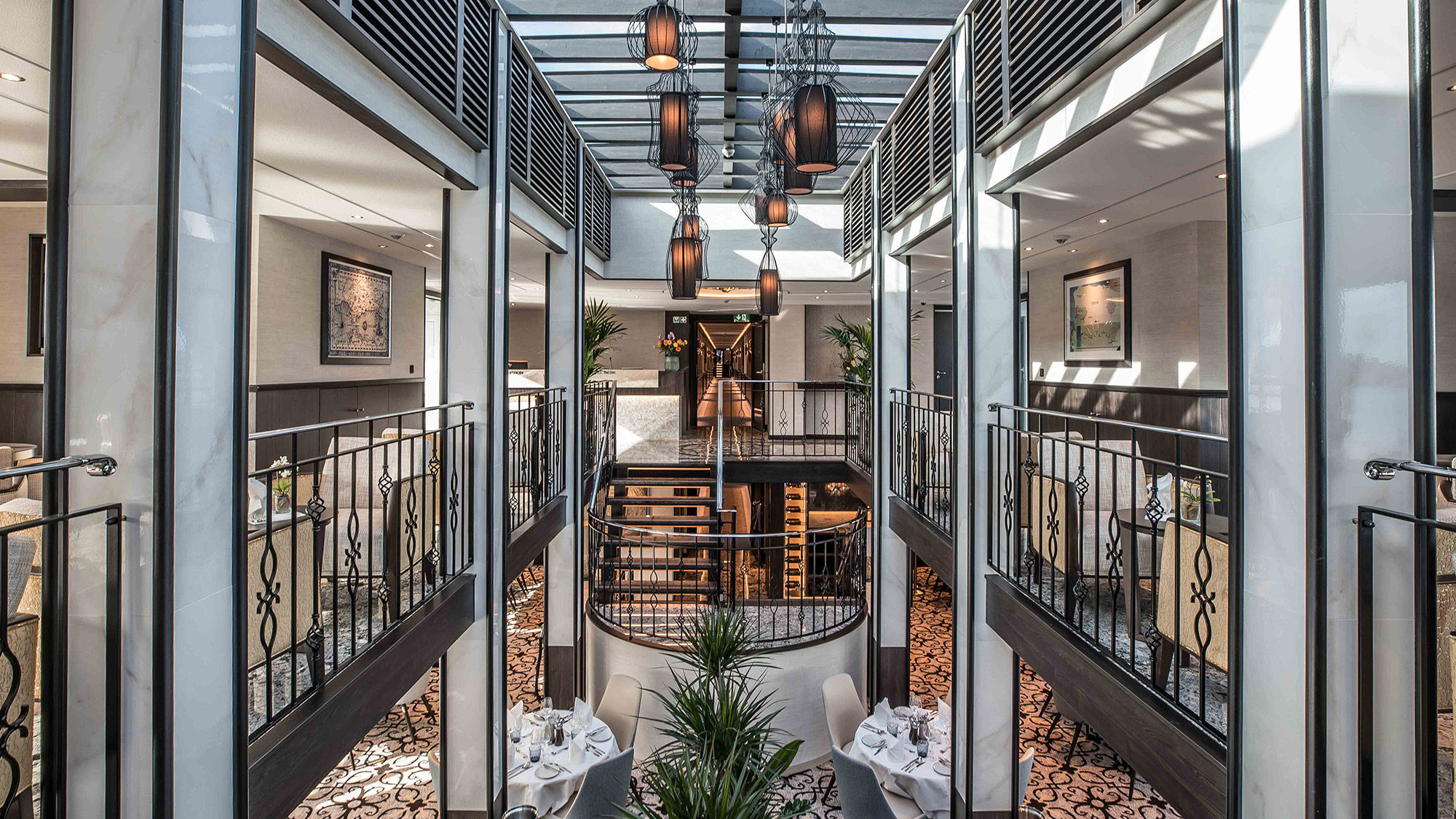 The Andorinha's atrium, showing azulejo-inspired ceiling lamps, railing and carpeting.