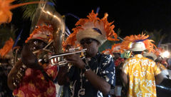 A Bahamian Junkanoo “street” parade winds its way to the beach as throngs of guests follow and dance along.