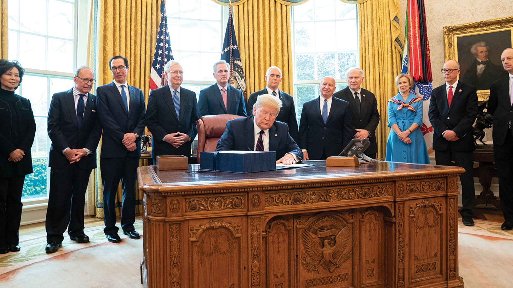 President Trump signs the Cares Act into law in the Oval Office.