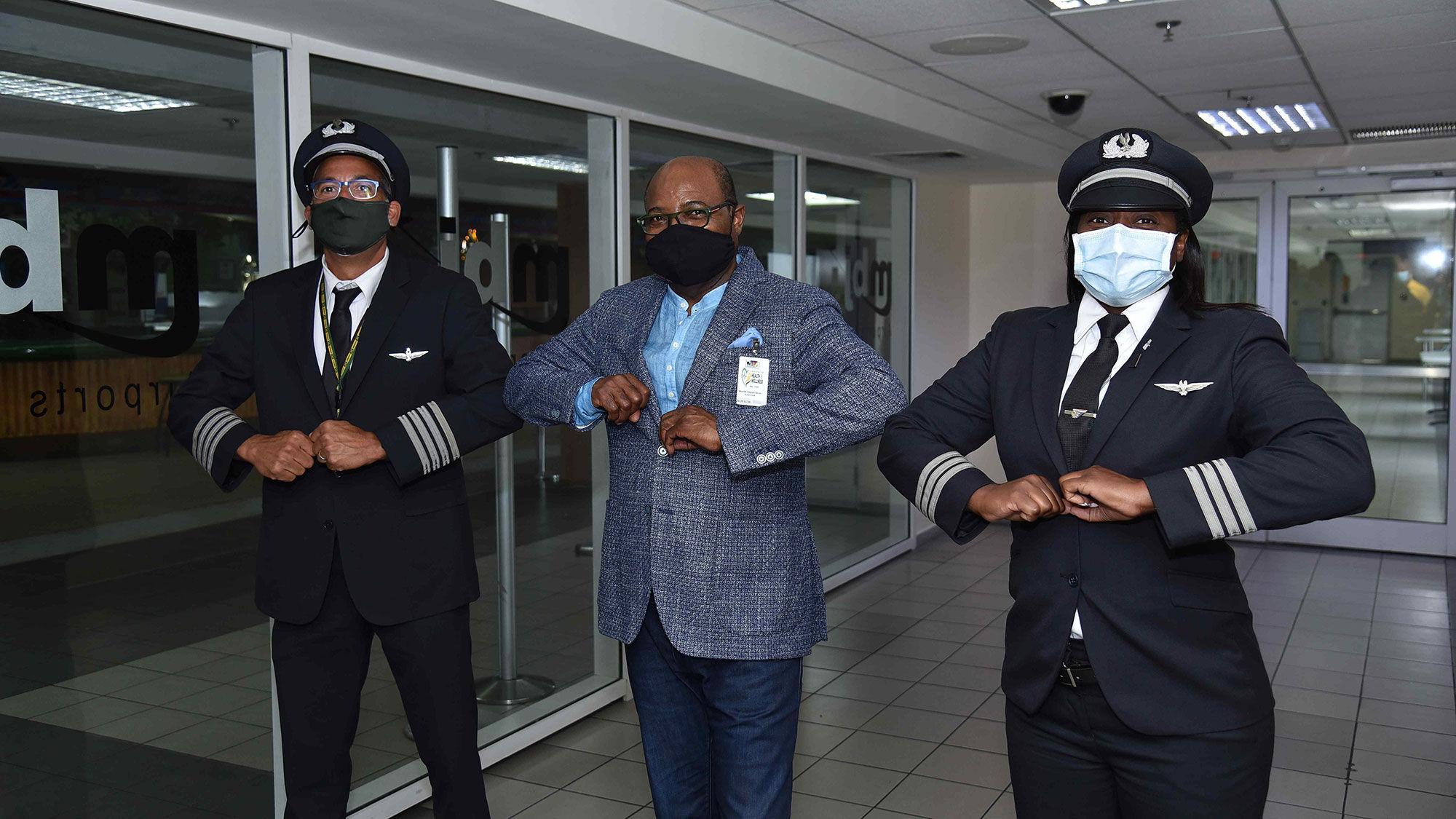 In June, Edmund Bartlett, Jamaica's minister of tourism, center, bumped elbows with American Capt. Shaun Nelson and first officer Bethoya Powell, who flew the first commercial flight into Sangster airport after a 3-momth hiatus.