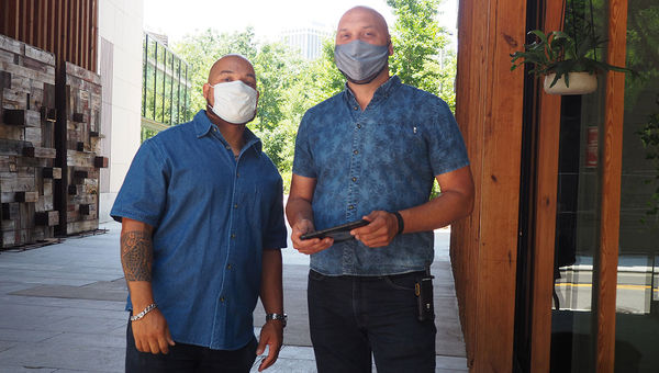 Staff wearing masks greet guests at the hotel's entrance. Staff wearing masks greet guests at the hotel's entrance.